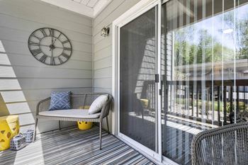 A patio with a chair and a clock on the wall